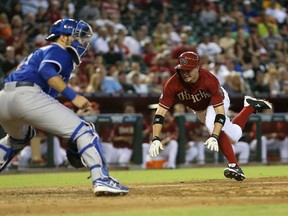 Arizona's Tony Campana, right, slides into home plate to score a run past Toronto catcher J.P. Arencibia during the seventh inning at Chase Field on September 4, 2013 in Phoenix. (Christian Petersen/Getty Images)