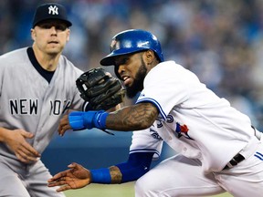 Toronto's Jose Reyes, right, gets caught in a run down against New York's Mark Reynolds in Toronto Thursday September 19, 2013. (THE CANADIAN PRESS/Mark Blinch)
