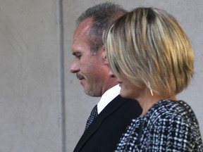 Windsor Police Const. Kent Rice and his wife leave the Ontario Provincial Court, Tuesday, Sept. 24, 2013, in Windsor, Ont, after his sentencing hearing. He was convicted in August of assaulting a 20-year- old man in an apartment building stairwell in February 2012. (DAN JANISSE/The Windsor Star)