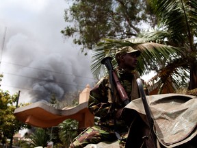 A soldier holds a RPG near the Westgate shopping mall in Nairobi, Kenya, as smoke rises from it, Monday Sept 23 2013. (AP Photo/ Sayyid Azim)
