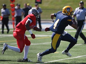 Windsor's Scott McEwan, right, tries to break free from Carleton's Tanaka Chakwesha during OUA football action at Alumni Field, Saturday, Sept. 14, 2013. The Lancers won 44-14. (DAX MELMER/The Windsor Star)