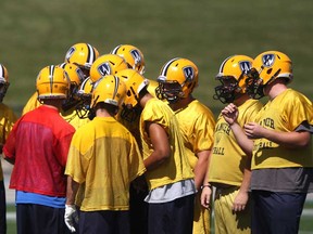 The University of Windsor football team huddles up during practice at Alumni Field. The Lancers host Carleton Saturday at 1 p.m.  (DAX MELMER/The Windsor Star)