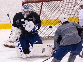 Toronto Maple Leafs goaltender Jonathan Bernier, left, makes a save in front of Jake Gardiner, centre, and Spencer Abbott during NHL training camp in Toronto on Thursday September 12, 2013. (THE CANADIAN PRESS/Chris Young)