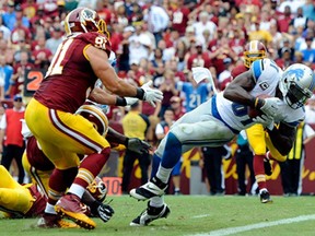 Detroit wide receiver Calvin Johnson, right, scores a touchdown in Landover, Md., Sunday, Sept. 22, 2013. (AP Photo/Alex Brandon)