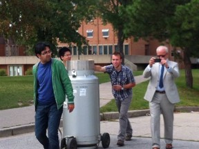 University of Windsor students, overseen by Andrzej Sobiesiak, the head of the mechanical engineering department, right, transport a tank designed to carry 200 litres of liquid nitrogen along Wyandotte Street West last Friday. The Dean of Engineering and the Ministry of Labour are both investigating the transportation of liquid nitrogen along a city sidewalk, which is illegal under the Dangerous Goods Act. (Courtesy of CUPE Local 1393 Facebook)