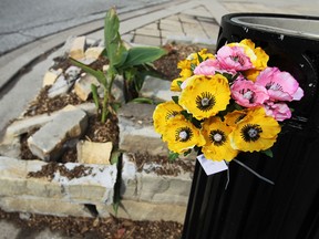 A damaged planter and garbage can are highlighted by a single bouquet of flowers along Sandwich Street in Windsor on Monday, September 9, 2013. A motorcyclist has died from the injuries he suffered after crashing into the plater and garbage can over the weekend.       (TYLER BROWNBRIDGE/The Windsor Star)