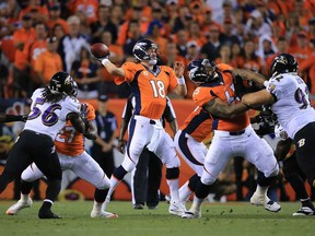 Peyton Manning, centre, of the Denver Broncos drops back to pass against the Baltimore Ravens September 5, 2013 in Denver. (Doug Pensinger/Getty Images)
