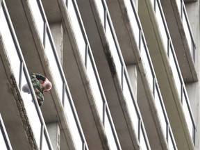 WINDSOR, ONT.: SEPT 15, 2013 -- A man looks up from his balcony at the charred exteriors of three condos after a fire broke out in a unit on the 26th floor at Victoria Park Place, Sunday, Sept. 15, 2013.  One person was taken to hospital with smoke inhalation and minor burns to their hands. (DAX MELMER/The Windsor Star)