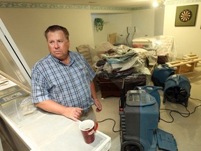 Southwood Lakes resident John Recker stands in his basement while fans and dehumidifiers deal with the aftermath of the past weekend's sewage flood. Photographed Sept. 3, 2013. (Tyler Brownbridge / The Windsor Star)