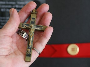 A woman holds a crucifix in this file photo. (Jason Kryk/The Windsor Star)