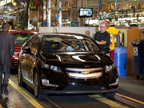 Assembly Plant Manager Teri Quigley, in car at left, shows the controls to President Barack Obama  as he prepares to drive the 2001 Chevy Volt during a tour at the General Motors plant in Hamtramck, Michigan, July 30, 2010. (Jim Watson/AFP/Getty Images)