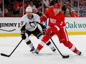 Detroit's Brendan Smith, right, takes a shot in front of Pittsburgh's Tanner Glass during a pre season game at Joe Louis Arena on September 25, 2013 in Detroit, Michigan. (Photo by Gregory Shamus/Getty Images