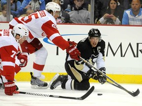 Pittsburgh's Sidney Crosby, right, makes a pass against Detroit's Danny DeKeyser, centre, and Daniel Cleary during a pre-season game on September 16, 2013 at the CONSOL Energy Center in Pittsburgh. (Vincent Pugliese/ Getty Images)