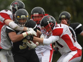 AKO's Austin Crumb, centre, is tackled by the Vancouver Island defence in the Canadian Junior Football League semifinal at Windsor Stadium Saturday. (DAX MELMER/The Windsor Star)