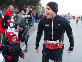 Mayor Eddie Francis stops for a quick hello with his family while he participates in the Detroit Free Press/Talmer Bank Marathon along Riverside Dr. W., Sunday, Oct. 20, 2013.  (DAX MELMER/The Windsor Star)