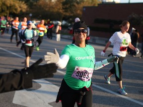 Runners participating in the Detroit Free Press/Talmer Bank Marathon slap five with the crowd as they make the turn off Goyeau Street and into the Detroit-Windsor Tunnel, Sunday, Oct. 20, 2013.  (DAX MELMER/The Windsor Star)