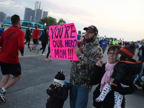 The Matte family, Rob Matte, centre, and his two children, Lewis Matte, 3, and Mick Matte, 1, along with grandma, Pat Matte, cheer on mom, Mikki Matte while she runs in the Detroit Free Press/Talmer Bank Marathon along Riverside Dr. W, Sunday, Oct. 20, 2013.  (DAX MELMER/The Windsor Star)