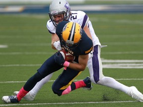 Windsor's Evan Pszconak, front, tries to escape the tackle from Western's Trevor Lass during OUA football action between the University of Windsor and Western at Alumni Field, Saturday, Oct. 5, 2013.  (DAX MELMER/The Windsor Star)