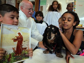 Deacon Gerard Charette and students Saif Yonan, left, Joe Helou, Ayonnah Tunks, Tammy Jackson, Carl Richards, top right, and Jazmyn Gannon, right, bless Bosco during the Feast of St. Francis of Assissi celebration at Immaculate Conception School on Victoria Avenue, Friday, Oct. 4, 2013.  St. Francis is known for his love of all of God's creatures. (NICK BRANCACCIO/The Windsor Star)