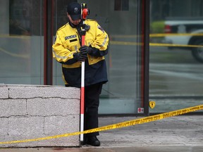A Windsor police officer works at the scene of an early morning fatal stabbing at the intersection of Park St. and Pelissier St., Saturday, Oct. 19, 2013.  Police cordoned off several blocks downtown after five people were stabbed in the early morning. One man died from his injuries.  (DAX MELMER/The Windsor Star)