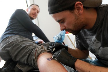 Tattoo artist Dave Kant works on a tattoo for Grant Yocom during Broken City Lab's free 'Windsor is Forever' tattoo event in Windsor in March 7, 2013. While Kant no doubt got his spelling right for the 25 clients he served that day, some tattoo recipients in other parts of the world haven't been so lucky. (Windsor Star files)