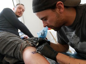 Tattoo artist Dave Kant works on a tattoo for Grant Yocom during Broken City Lab's free 'Windsor is Forever' tattoo event in Windsor in March 7, 2013. While Kant no doubt got his spelling right for the 25 clients he served that day, some tattoo recipients in other parts of the world haven't been so lucky. (Windsor Star files)