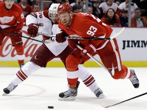 Phoenix forward Antoine Vermette, left, checks Detroit's Johan Franzen in Detroit. (AP Photo/Paul Sancya)