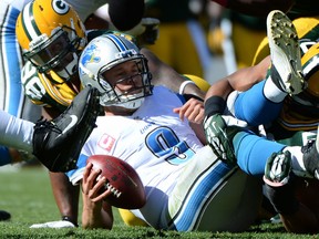 Detroit's Matthew Stafford, right, is sacked by Green Bay's Mike Neal at Lambeau Field. (Photo by Harry How/Getty Images)