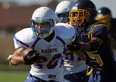 St. Anne's Braeden Braccio, left, breaks a tackle by St. Joseph's Caleb Uddyback at St. Joseph high school. (TYLER BROWNBRIDGE/The Windsor Star)