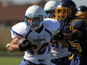 St. Anne's Braeden Braccio, left, breaks a tackle by St. Joseph's Caleb Uddyback at St. Joseph high school. (TYLER BROWNBRIDGE/The Windsor Star)