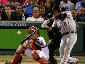 Detroit's Jhonny Peralta, right, hits a double in front of Boston catcher David Ross in the eighth inning during Game 1 of the American League baseball championship series Saturday in Boston. (AP Photo/Charlie Riedel)