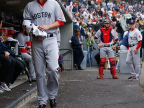 Boston pitcher John Lackey waits in the dugout after stadium lights went out at Comerica Park to delay the game in the second inning during Game 3 of the American League championship series. (AP Photo/Paul Sancya)