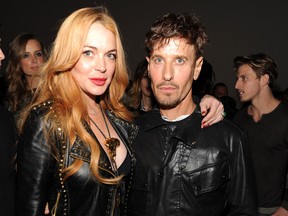 Troubled star Lindsay Lohan, left, with photographer Steven Klein, is considering working with investors in order to lend her name to her own rehabilitation centre. (Getty Images files)