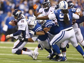 Peyton Manning #18 of the Denver Broncos is sacked during the game against the Indianapolis Colts at Lucas Oil Stadium on October 20, 2013 in Indianapolis, Indiana.  (Photo by Andy Lyons/Getty Images)