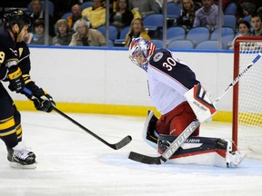 In this file photo, Buffalo Sabres forward Steve Ott (9), a former Windsor Spitfire, shoots the puck at Columbus Blue Jackets goaltender Mike McKenna (30) who stops it between his stick and pads during the first period of an NHL hockey preseason game in Buffalo, N.Y., Wednesday, Sept. 25, 2013. (AP Photo/Gary Wiepert)