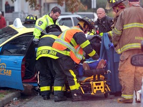 Windsor firefighters and Windsor-Essex EMS paramedics work to free the driver of a taxi following an accident with a pickup truck on Assumption Street and Marentette Avenue in Windsor, Ontario on October 31, 2013.   The exact extent of injuries were not known at the scene.  Windsor Police are investigating.  (JASON KRYK/The Windsor Star)_