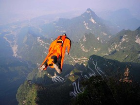 In this Tuesday, Oct. 8, 2013 photo, Hungarian wingsuit flier Viktor Kovats jumps off a mountain at Tianmen Mountain National Forest Park in Zhangjiajie in south China's Hunan province. Kovats died during this fatal jump into a gorge. His body was recovered Wednesday from the steep, forested valley floor at the park, state broadcaster CCTV said. The reports said the highly experienced Kovats apparently died from a head injury after crashing into a cliff-side. His 700-metre (2,290-foot) jump Tuesday afternoon was part of preparations for the Second World Wingsuit Championship being held in the park from Oct. 11 to 13. (AP Photo)
