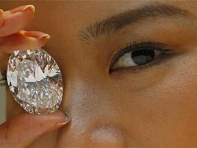 In this Thursday, Sept. 19, 2013 file photo, a 118.28-carat white diamond is displayed by a model at a press preview at Sotheby's auction house in Hong Kong.  (AP Photo/Vincent Yu, File)
