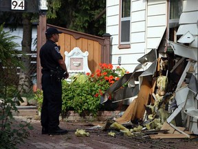A police officer surveys the damage after a fire at 94 Gore St. in Amherstburg on Thursday, October 3, 2013. The blaze broke out around 3 p.m. and forced the residents from the home. No one was seriously injured in the fire.           (TYLER BROWNBRIDGE/The Windsor Star)