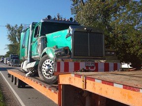 Crews from Coxon's Towing work to remove a transport truck from a ditch on Belle River Road between Highway 401 and County Road 46 in Lakeshore Ontario. (TwitPic: Jason Kryk/The Windsor Star)