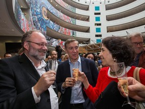 Physicist of the European Organization for Nuclear Research (CERN) Albert de Roeck, left, Joe Incandela, centre, and Fabiola Gianotti, right, celebrate with sparkling wine after the announcement of the physics Nobel prize at the European Particle Physics laboratory (CERN), in Meyrin near Geneva, Switzerland, Tuesday, Oct. 8, 2013. Britain's Peter Higgs and Francois Englert of Belgium won the Nobel Prize for physics on Tuesday for predicting the existence of the Higgs boson particle, detected in 2012 at the European Organization for Nuclear Research (CERN). (AP Photo/Keystone, Salvatore Di Nolfi)