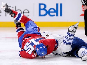 George Parros #15 of the Montreal Canadiens falls to the ice head first during his their period fight with Colton Orr #28 of the Toronto Maple Leafs during the NHL game at the Bell Centre on October 1, 2013 in Montreal, Quebec, Canada. The Maple Leafs defeated the Canadiens 4-3. (Photo by Richard Wolowicz/Getty Images)