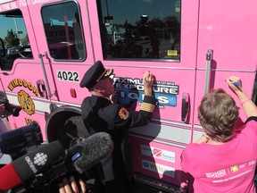Windsor Fire and Rescue  Chief Bruce Montone, left and Canadian Cancer Society Windsor-Essex Office Manager Judy Lund sign the WFD pink fire truck as they launch the Get Your Pink On! Fight Cancer with Fire! campaign at Devonshire Mall on October 10, 2013.  (JASON KRYK/The Windsor Star)