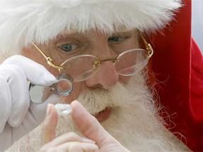 Actor Brady White portrays Santa Claus as he looks at a 25-carat rough Forevermark diamond offered in the Neiman Marcus Christmas Book Tuesday, Oct. 8, 2013, in Dallas. (AP Photo, LM Otero)