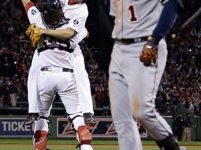 Boston relief pitcher Koji Uehara, rear, and catcher Jarrod Saltalamacchia celebrate the 5-2 victory as Detroit's Jose Iglesias leaves the field after Game 6 of the American League  championship series Saturday. (AP Photo/Matt Slocum)