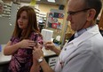 Pharmacist Gary Willard at Ziter Pharmacy on Howard Avenue gives a flu shot to Tanya McIntosh Wednesday October 23, 2013. (NICK BRANCACCIO/The Windsor Star)