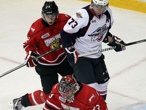 Spitfires forward Remy Giftopoulos, centre, is checked by Owen Sound's Tyler MacArthur in front of goaltender Brandon Hope Thursday. (TYLER BROWNBRIDGE/The Windsor Star)