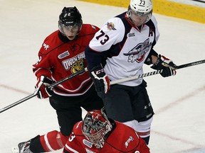 Spitfires forward Remy Giftopoulos, centre, is checked by Owen Sound's Tyler MacArthur behind goaltender Brandon Hope at the WFCU Centre.  (TYLER BROWNBRIDGE/The Windsor Star)