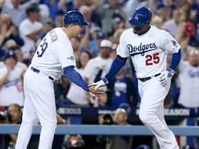 Los Angeles third base coach Tim Wallach, left, congratulates Carl Crawford after Crawford hit a home run against the Atlanta Braves in Game 4 of the National League Division Series at Dodger Stadium.  (Photo by Stephen Dunn/Getty Images)