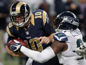 St. Louis quarterback Kellen Clemens, left, is tackled by Seattle's Chris Clemons Monday in St. Louis. (AP Photo/Tom Gannam)